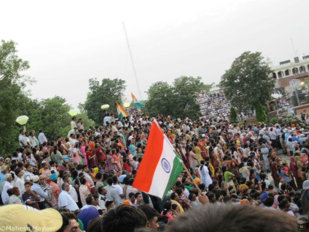 An Indian flag flutters prominently as a crowd gathers on the Indian Side of the Wagah border in Punjab India1