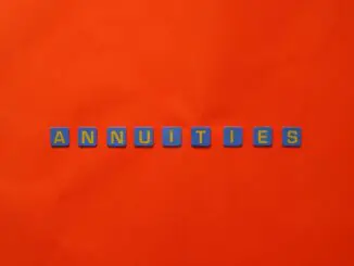 Conceptual image of the word annuity 'Annuities' spelled with tiles on a vibrant red background.