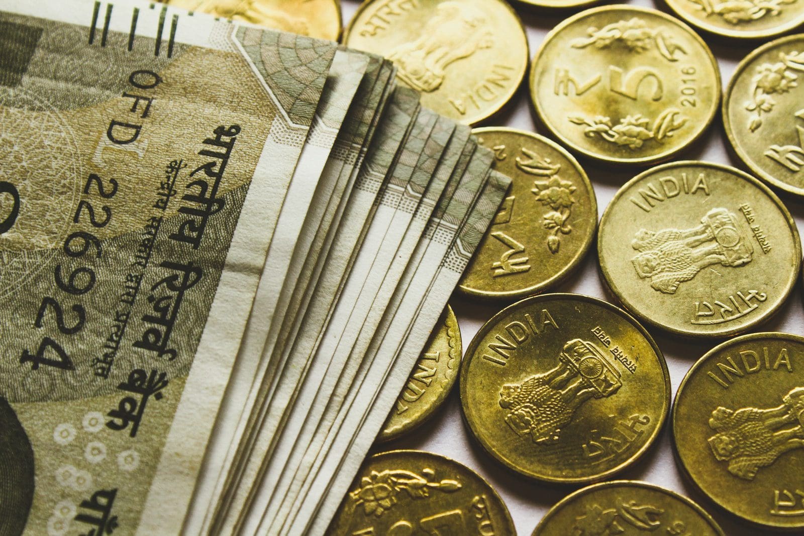 Private wealth manager round gold-colored rupee coins and banknotes